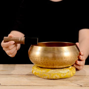 Grand bol chantant tibétain joué avec maillet sur coussin — VITALIA PARIS