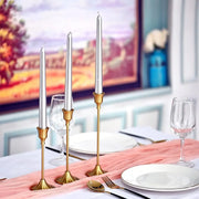 Set de bougeoirs fins cuivrés dressé sur une table